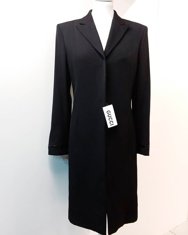 Cappotto primaverile lungo nero marcato Gucci indossato da un manichino
