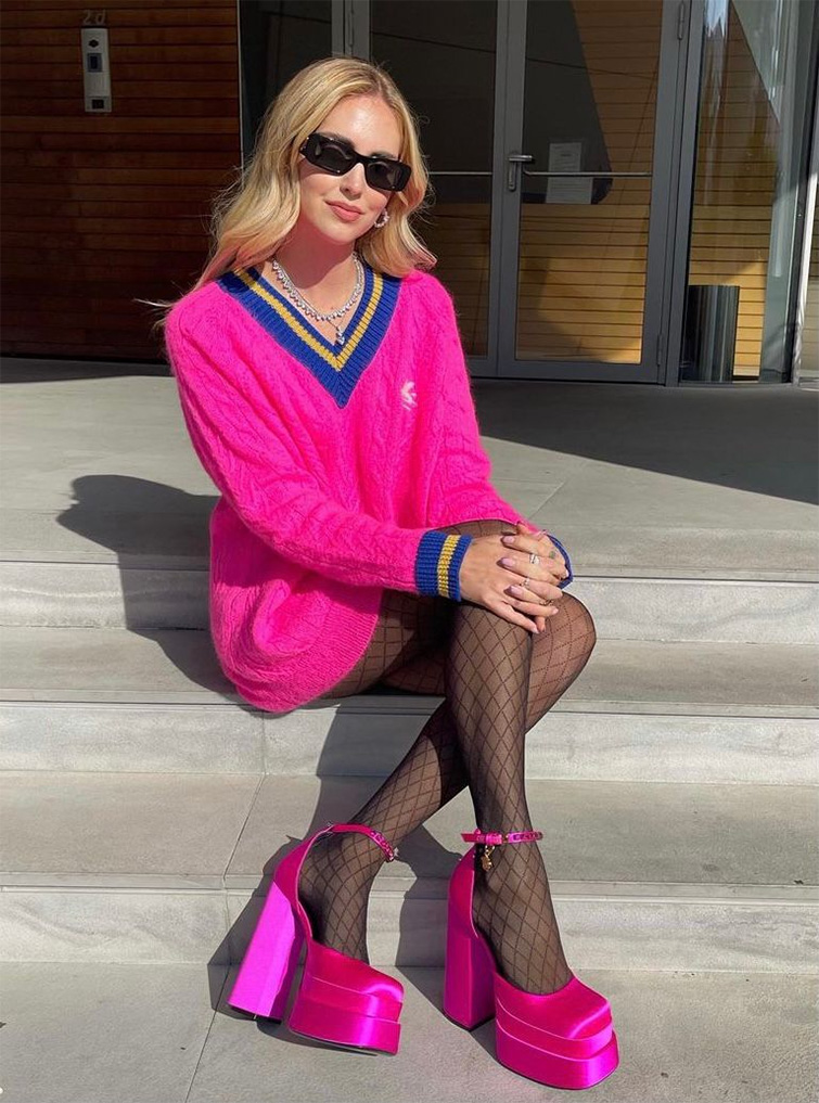 Influencer di moda Chiara Ferragni seduta sugli scalini con dei vestiti colorati e le mani sulle ginocchia