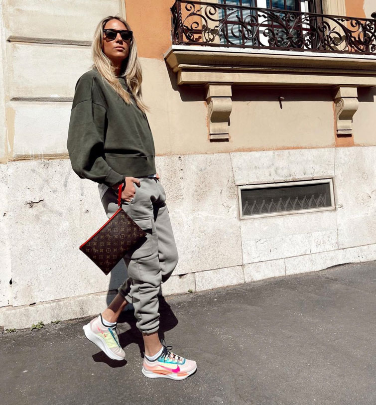 Influencer italiana Alice Campello in posa mentre indossa una borsa Louis Vuitton originale in mezzo al marciapiede