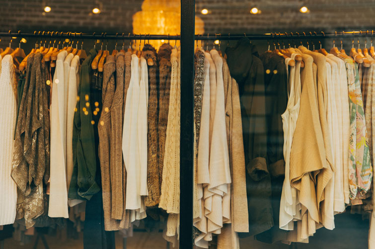 esterno di una vetrina di un negozio di abbigliamento usato a Padova in cui si possono vedere tutti i vestiti attaccati sull’attaccapanni