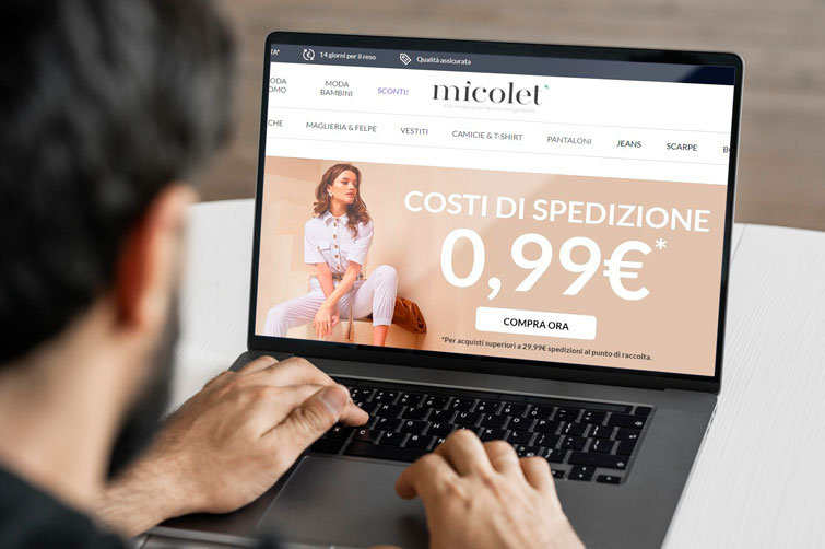 ragazzo che sta cercando sul suo computer situato su un tavolo bianco abbigliamento usato a Padova sulla piattaforma online Micolet